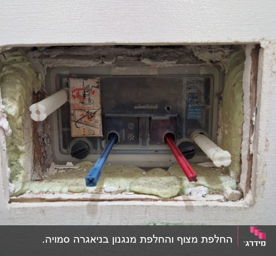 תמונה של צנרת מים בקיר עם חיבורים צבעוניים